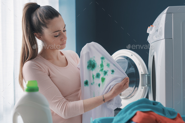 Disappointed housewife holding stained clothes