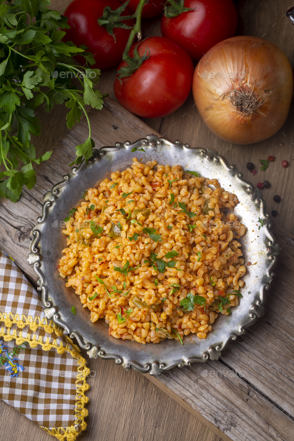 Traditional turkish bulgur pilaf with tomato sause in plate (Turkish