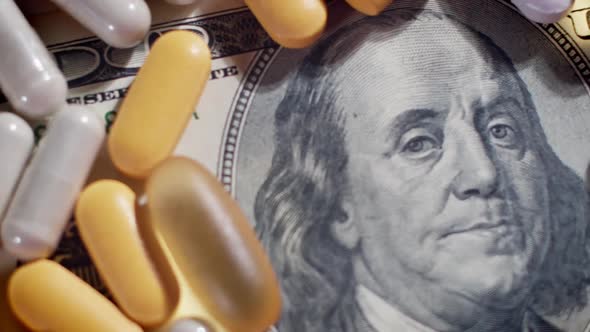 Medical pills lying on top of hundreds of US Dollar Bill. Big pharma conspiracy theory