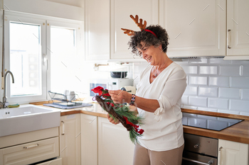 A senior woman holding a Christmas ornament to decorate her home