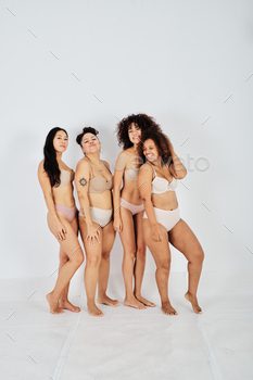 Delighted young different diverse females in underwear standing in studio