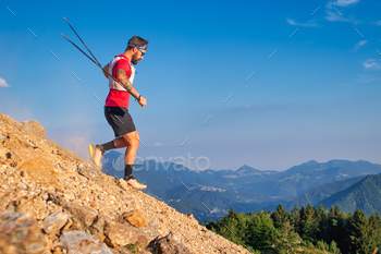 Man descending with poles on a rocky slope