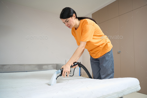 Lady performing general cleaning of sleeping mattress