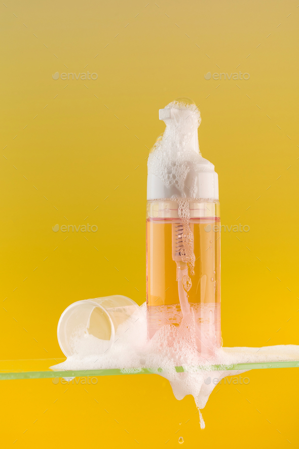 Dispenser mockup with face wash foam on a glass shelf on a yellow background. Acne remover.