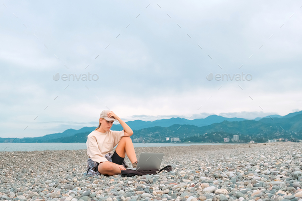 Remote work.Girl freelancer works remotely on the sea shore. workation, remote work,WFVH,Van Life
