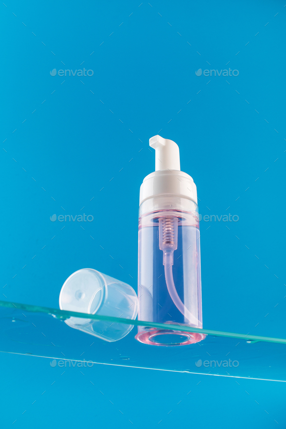 Dispenser mockup with face wash foam on a glass shelf. Acne remover, makeup remover. Skin care.