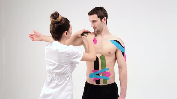 Shoulder treatment with kinesio tape. Physiotherapist applying elastic therapeutic tape alt