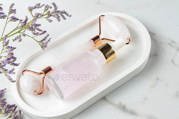 Cosmetic rose essential oil and rose quartz roller facial massager for facial beauty massage at home