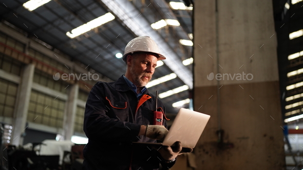 Factory engineer using laptop in the factory