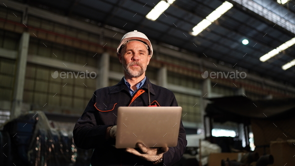 Factory engineer using laptop in the factory