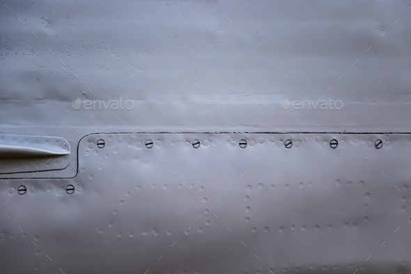 Aircraft skin close up. Rivets on gray metal. Stock Photo by Statuska