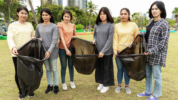 Asia Woman Group Team Volunteer picking up Trash plastics garbage plastic waste.