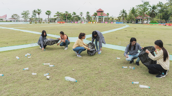 Asia Woman Group Team Volunteer picking up Trash plastics garbage plastic waste. Friend putting