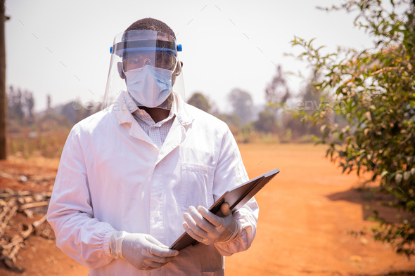 Successful African doctor, he wears a lab coat, a surgical mask and a protective face shield