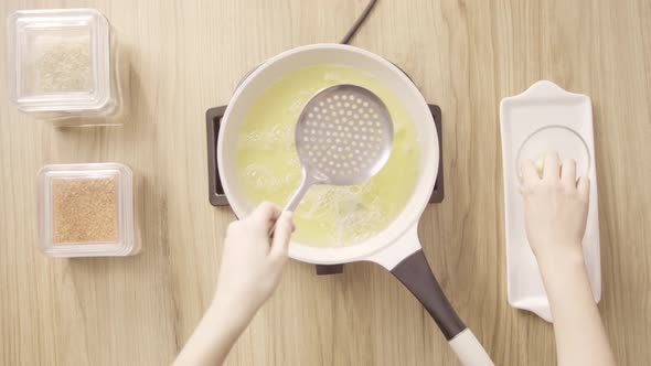 Frying Ramadan Briwat in white pot with burning oil, top shot static. alt