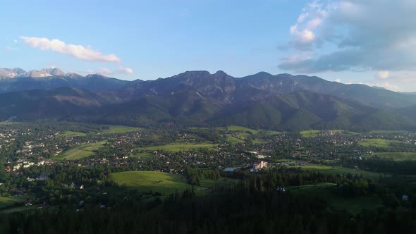 Aerial view of green hills in summer. Giewont massif in the Tatra Mountains and view of Zakopane. 