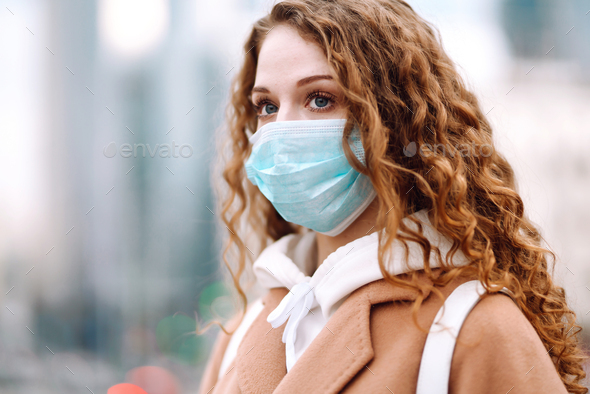 Woman in protective medical mask on her face on the street. Woman, wear face mask. Corona virus.