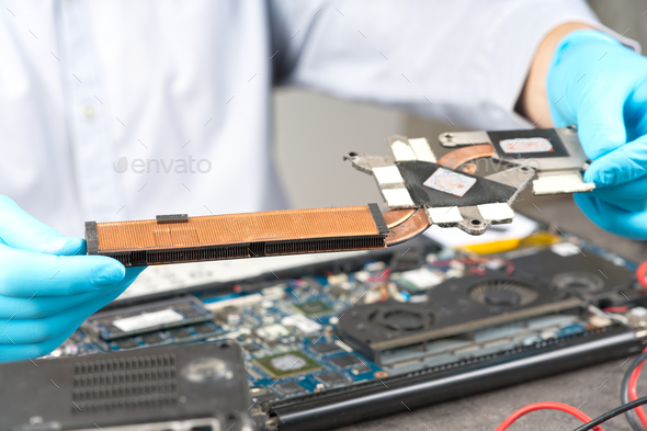 Hands fixing motherboard of pc or laptop notebook close up in service. Laptop repair service.