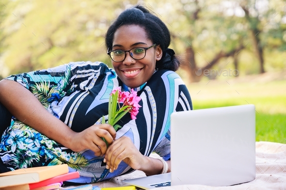 Happy young African American. Cheerful African American woman in the park. African American student; - Stock Photo - Images