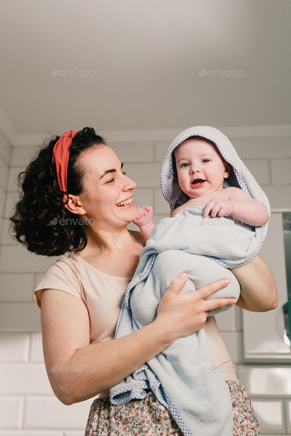 Little baby in towel after bathing on the mother’s hands . Personal