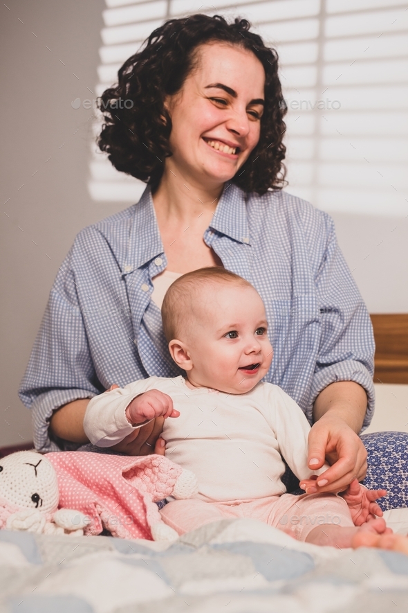 Mother and baby on the bed . Family at home. Candid portraits Stock