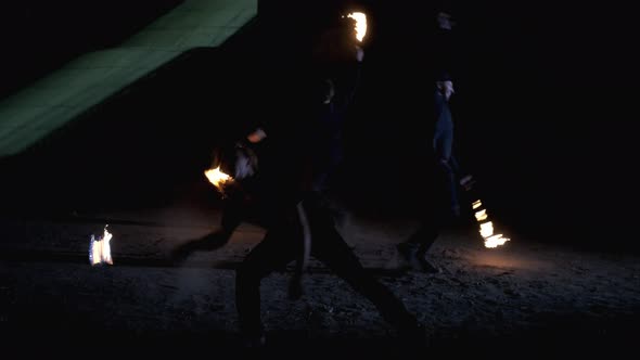 Man with a torch breathes fire. Two  men spinning chains of fire. Fire show alt