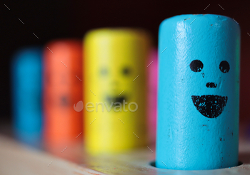 Close up of smiley faces on a colorful wooden children’s toy