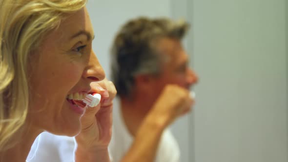 Couple brushing teeth in bathroom  alt