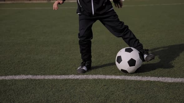 Closeup of Little Boy Soccer Player Trains on a Soccer Field with Green Grass alt