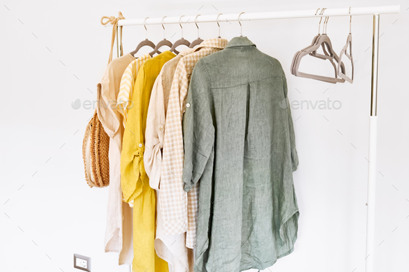 Linen clothes on gray hangers on the clothes rack. Slow Fashion. Conscious consumption.