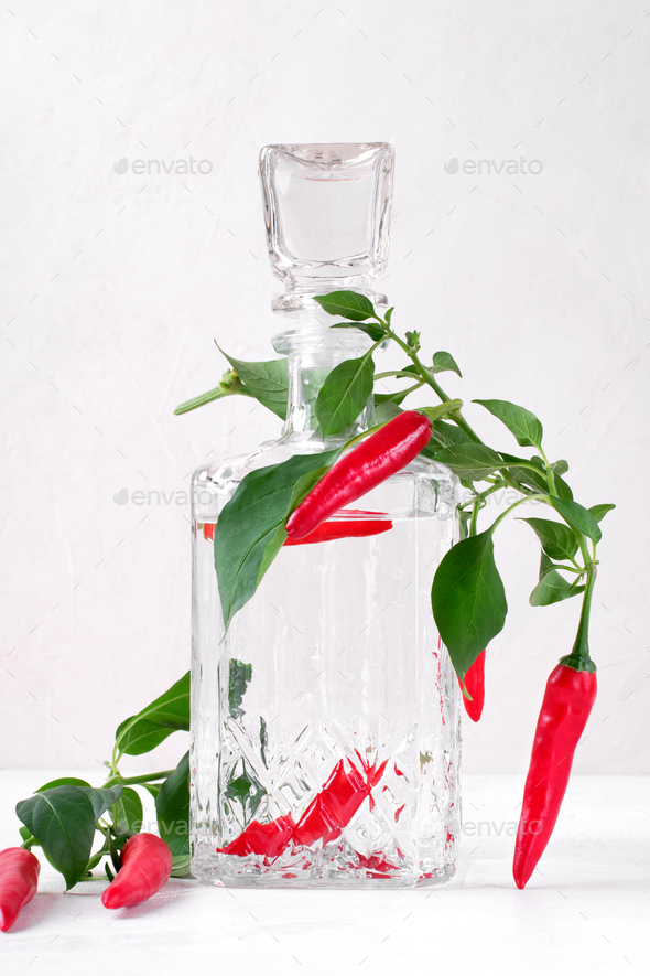 Pepper infused vodka in glass decanter decorated with chili pepper