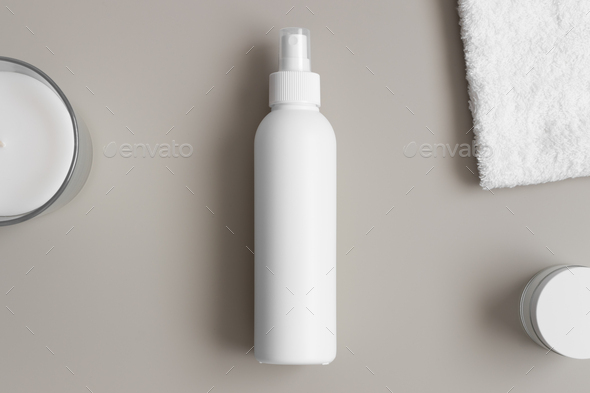 White cosmetic spray bottle mockup with a towel on the beige table.