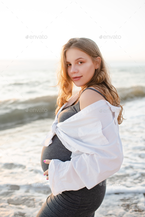 Pregnant woman 20-24 year old wear casual dress and shirt over sea nature background outdoor
