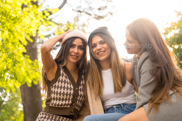 Women friends in a park in autumn carefree, fashionable autumn lifestyle with positive energy