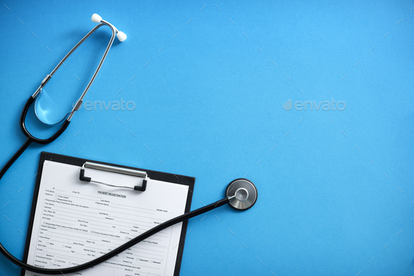 Overhead Flat Lay Medical Shot Of Stethoscope And Patient Registration Form On Clipboard