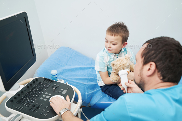 Caucasian boy carefully observing what medical worker doing