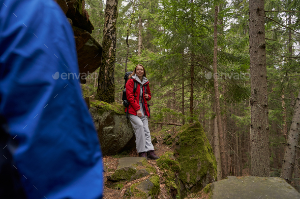 Hiker resting against rock following her companion with gaze Stock Photo by  Iakobchuk