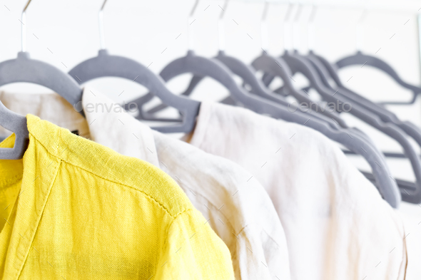 Linen clothes on gray hangers on the clothes rack. Slow Fashion.