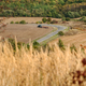 autumn landscape with dry grass, road across agricultural fields, tractor work on agricultural land - PhotoDune Item for Sale