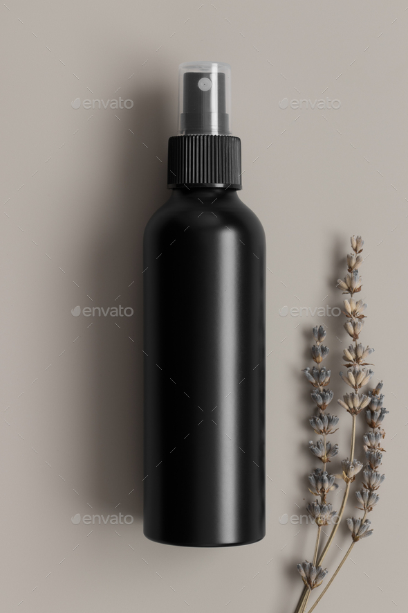 Black cosmetic spray bottle mockup with a lavender on the beige background.