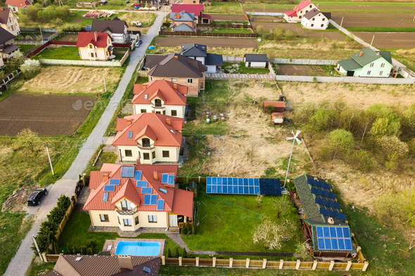 Aerial view of a private house with green grass covered yard, solar panels on roof
