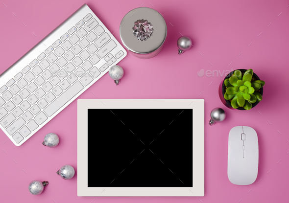 Christmas home office desk with computer, christmas tree, gift, silver decorations. Flat lay, top vi