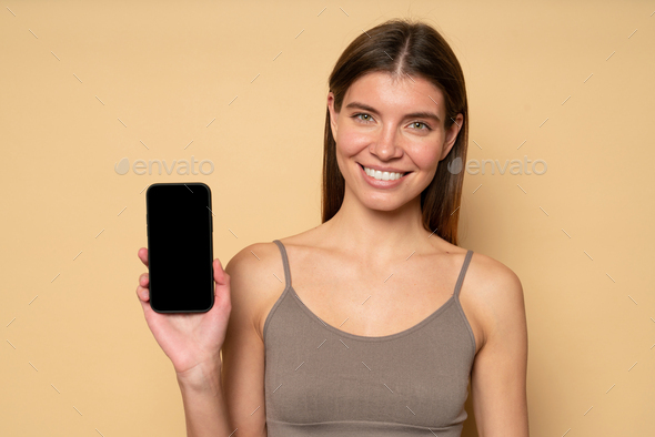 Portrait of woman showing black mockup phone screen recommending to download fitness app - Stock Photo - Images