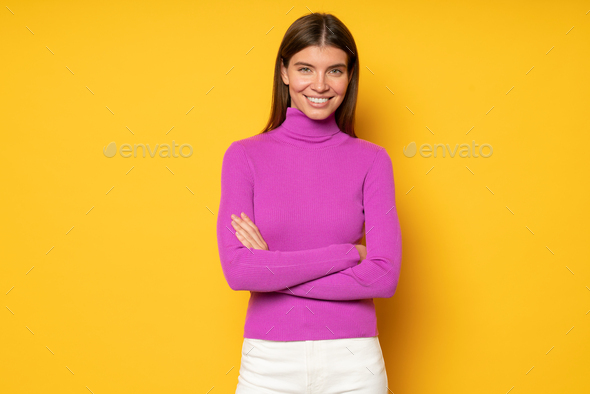 Bossy woman sharing secrets of successful start up standing on yellow background with crossed hands