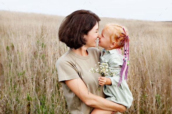 Happy mother and daughter hugging in nature. Family is smiling. Natural color, Lifestyles