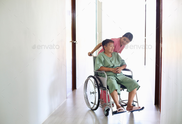 Caring nurse talking with old patient in living room at homecare visit. Medicine caregiving concept