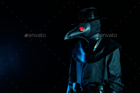 Portrait of plague doctor with crow-like mask isolated on black background. Creepy mask