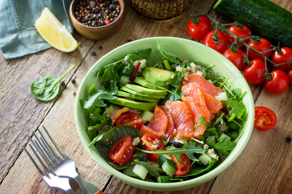 Diet menu, vegan food. Healthy salad with quinoa, arugula, tomatoes, salmon and avocado.