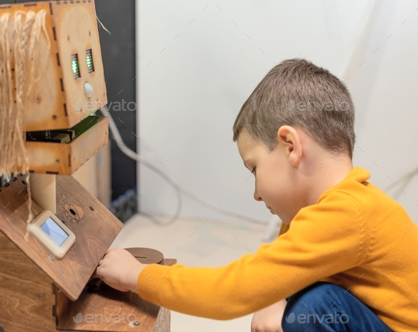 Child boy playing with cute robot. Concept of modern lifestyle and emerging technologies