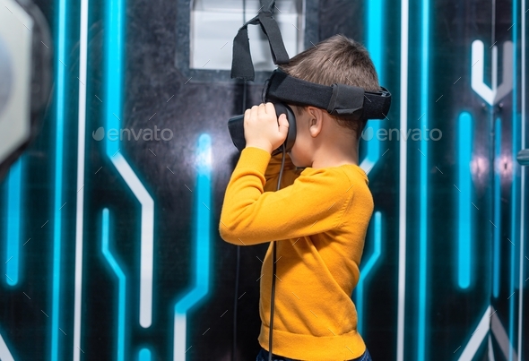 Child boy using virtual or augmented reality glasses. Concept of modern lifestyle and technologies